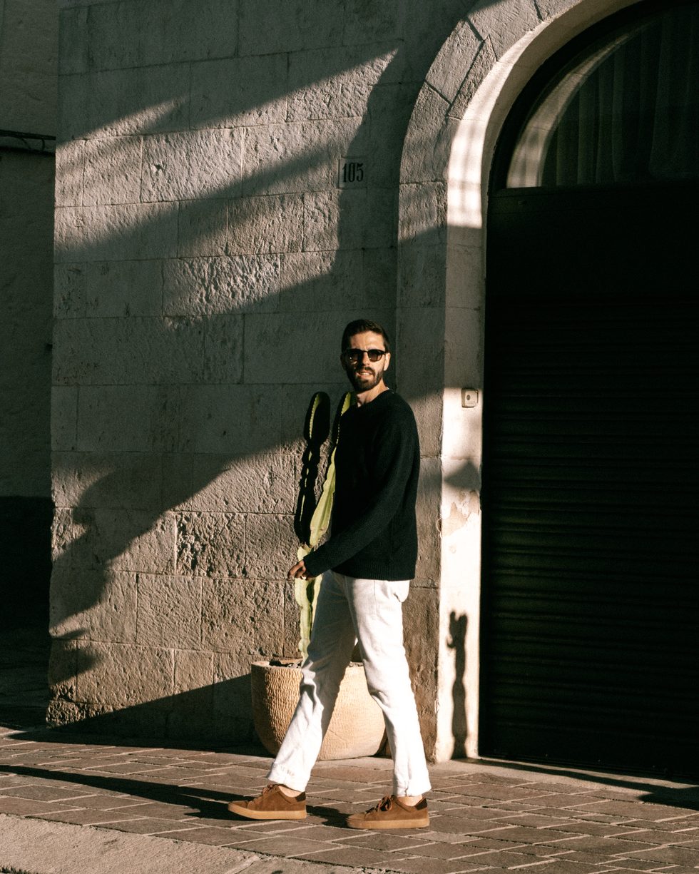 Jose Chiriboga walking past an arched doorway in late afternoon light